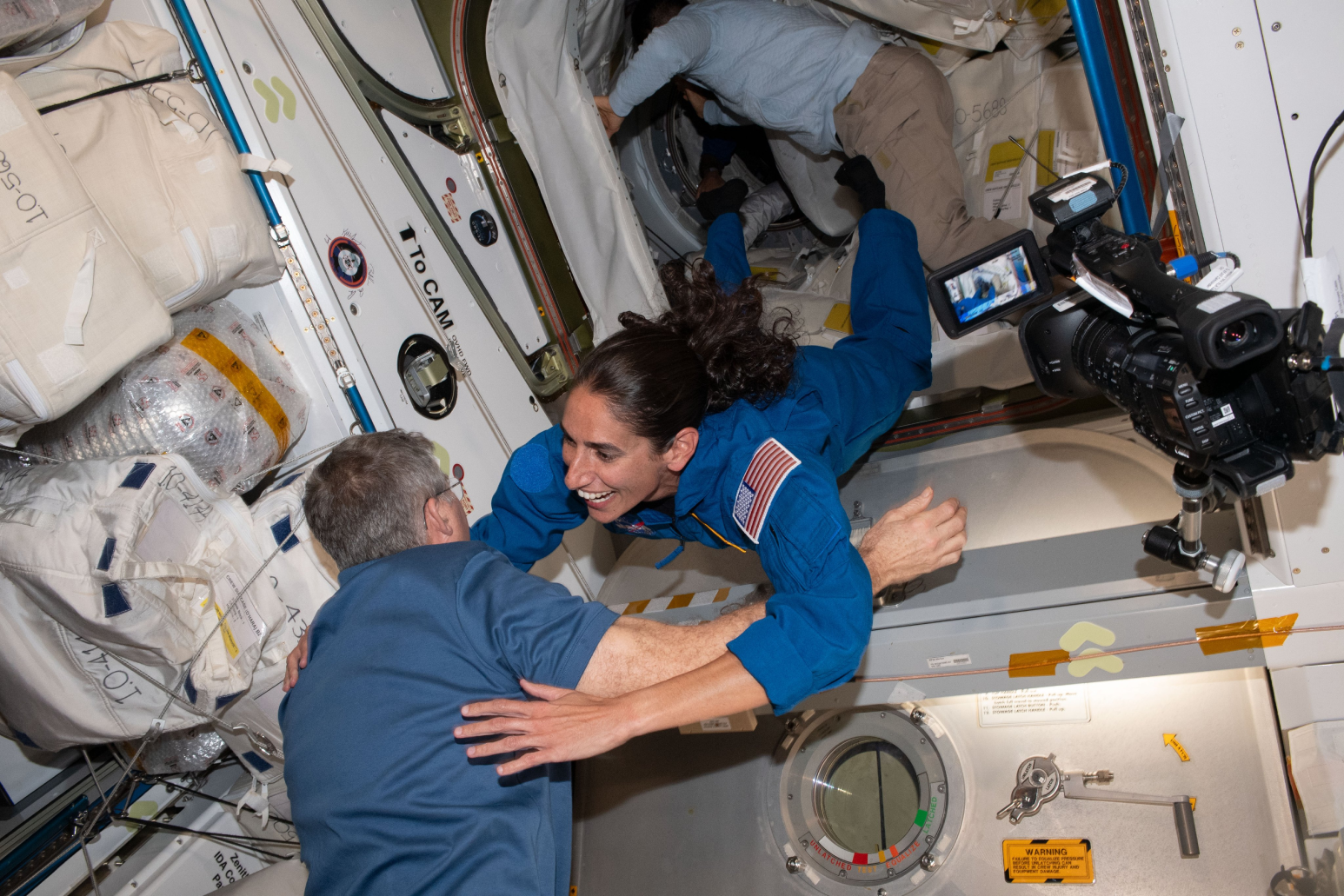 Jasmin Moghbeli and Steve Bowen meeting inside the Harmony module on the International Space Station.